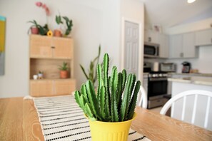 A cactus in a yellow pot on a wooden table with a striped placemat. - Artisan Poolside Paradise near Disney (Clermont)