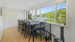 Un espace repas avec vue sur un lac et une forêt.