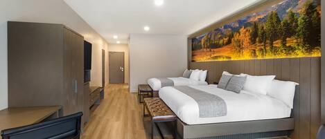 Une chambre d’hôtel moderne équipée d’un grand lit, d’un bureau, d’une banquette et d’un téléviseur.