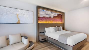 Un dormitorio moderno con cama, sofá y una obra de arte colgada en la pared.