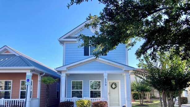 A two-story house with a front porch, a garage, and a driveway. - Beach side vacation house (Myrtle Beach)