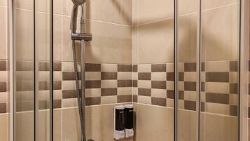 Une douche équipée d’un pommeau de douche à main et d’un panneau de commande fixé au mur.