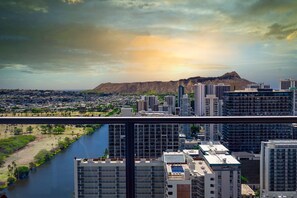A cityscape with high-rise buildings, a river, and a mountain in the background.
