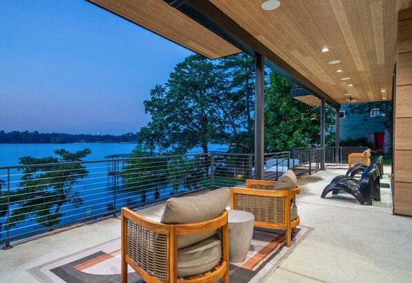 Relax in a serene outdoor space with wicker furniture and a view of the water.