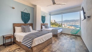 A bedroom with two beds, a ceiling fan, and a view of a cityscape through large windows. - LUXO Villa Acapulco Zona Brisas Guitarrón (Acapulco)