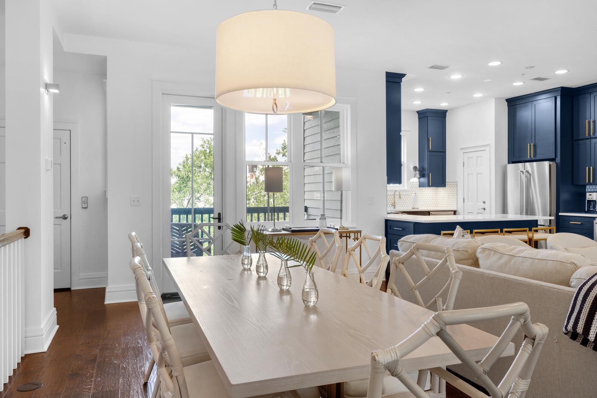 A modern kitchen with dark blue cabinets, a white countertop, and a large window.