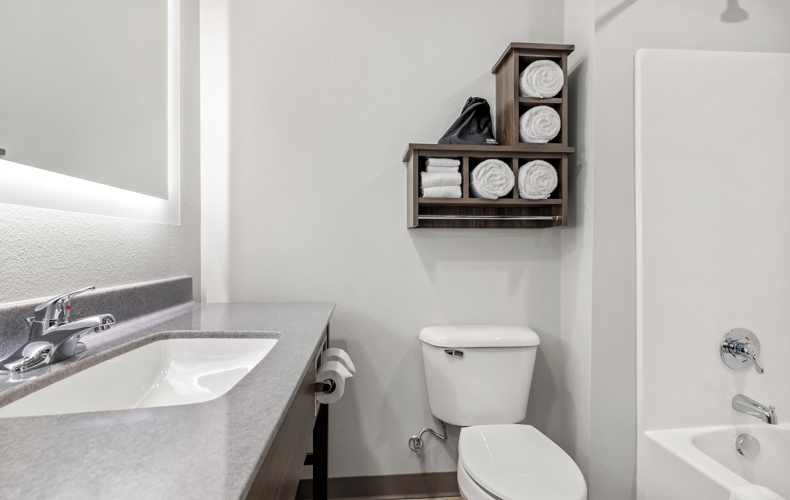 A bathroom with a sink, toilet, and a shelf with towels.