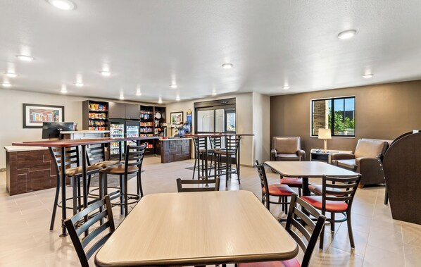 A modern hotel lobby with a bar, seating area, and a view of the outdoors.