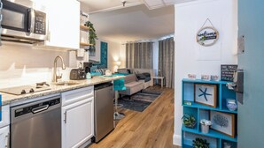 A modern kitchen with a dishwasher, microwave, and a coffee maker.