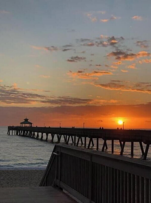 Guests can enjoy a serene waterfront experience from this picturesque pier, featuring a simple open design and a small lookout at the end.