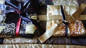 Un lit bien fait, avec une couverture à motifs.