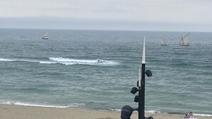 A beach with a sailboat in the distance and a pole with lights in the foreground. - Apartment with sea view, at the foot of the beach, ideal for a couple with 2 children (Saint-Cyprien)