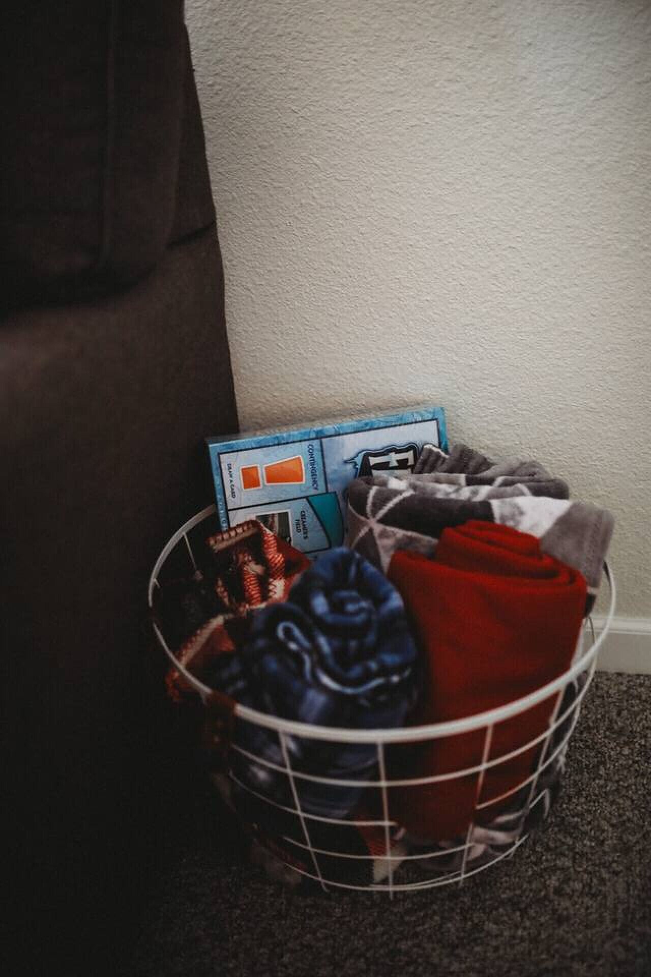 A basket with folded clothes and a board game.