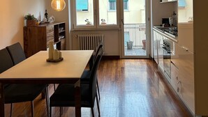 A modern kitchen with a dining area, wooden flooring, and pendant lighting. - Roma [appartamento Moderno e Luminoso] (Roma)