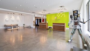 A spacious lobby with a reception desk, a sofa, and a robot. - 1/1 Condo-Hotel with double bed and community pool miles from Disney! (Kissimmee)