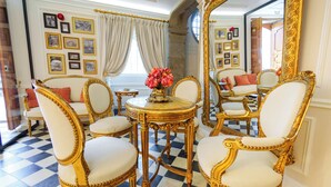 Una habitación con muebles dorados ornamentados, piso a cuadros y un espejo grande.
