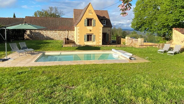A two-story house with a swimming pool, surrounded by a well-maintained lawn and a stone wall. - "Sur la colline": country house with heated pool, near Sarlat. (Domme)
