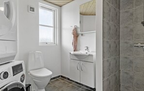 Baño pequeño con inodoro, lavadora y lavabo.