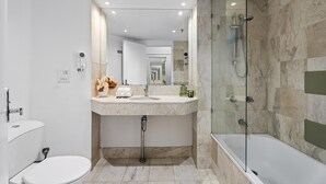 A modern bathroom with a glass-enclosed shower, a white sink, and a toilet. - Twin Unit with Ocean View in Surfers Paradise (Surfers Paradise)