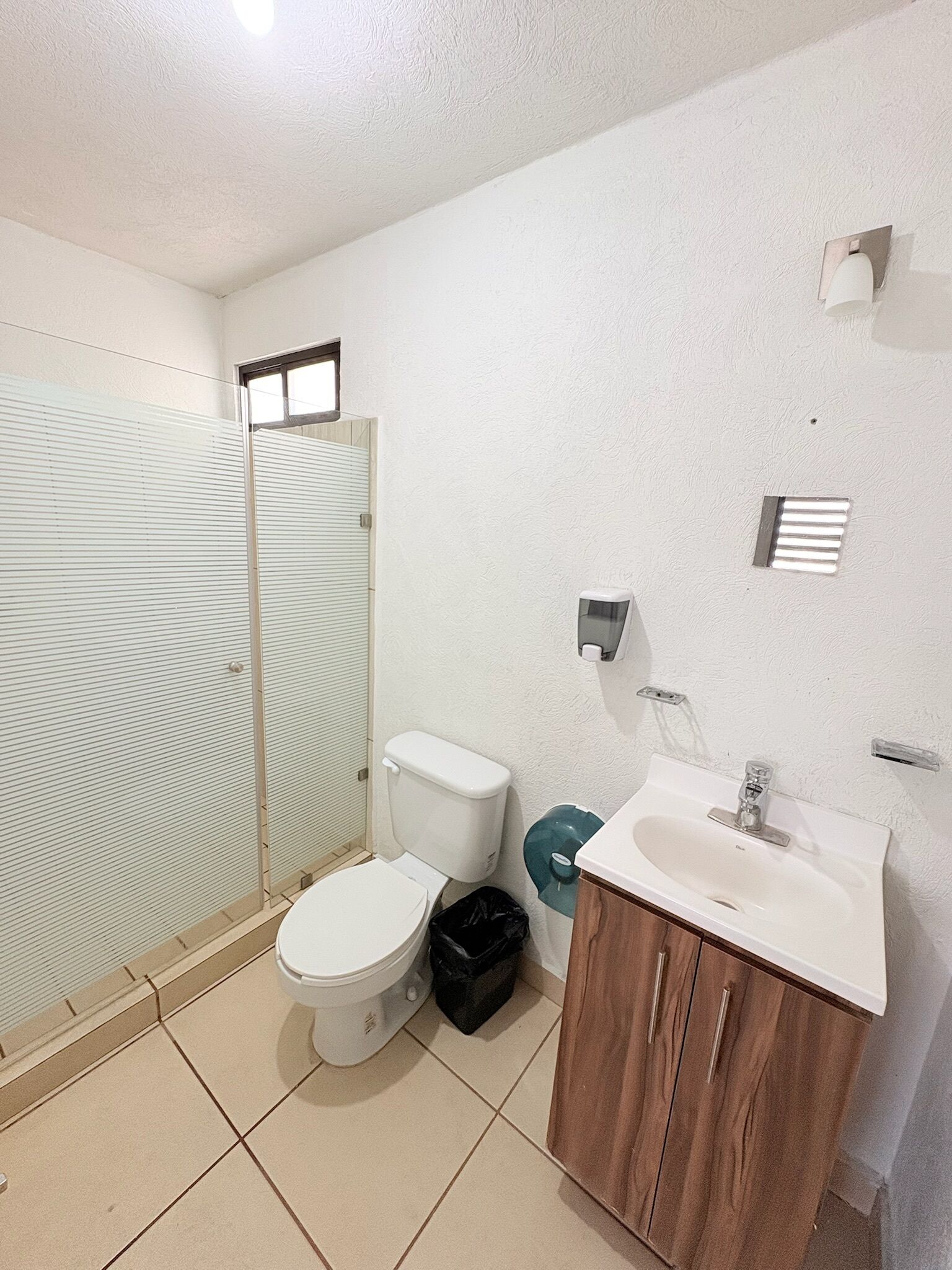 Une salle de bain comprenant des toilettes, un lavabo et un espace douche.