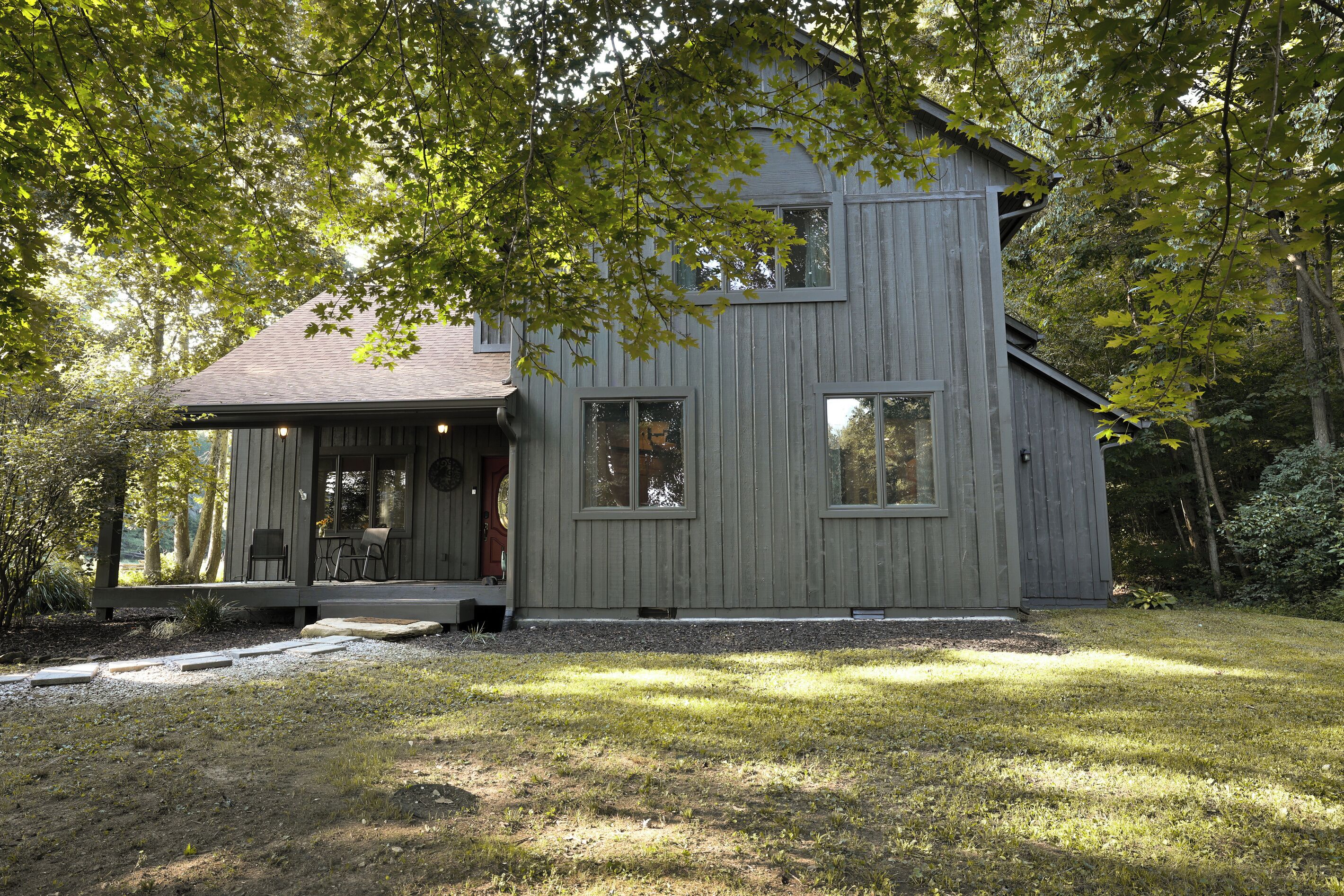 A two-story house with a porch and a small garden area.