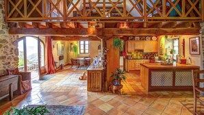 Una cocina amplia con techo de madera, paredes de piedra y una isla grande.