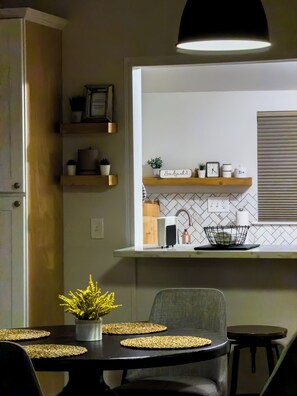 Een moderne keuken met een inbouwoven, een spoelbak en een aanrecht met een koffieapparaat.
