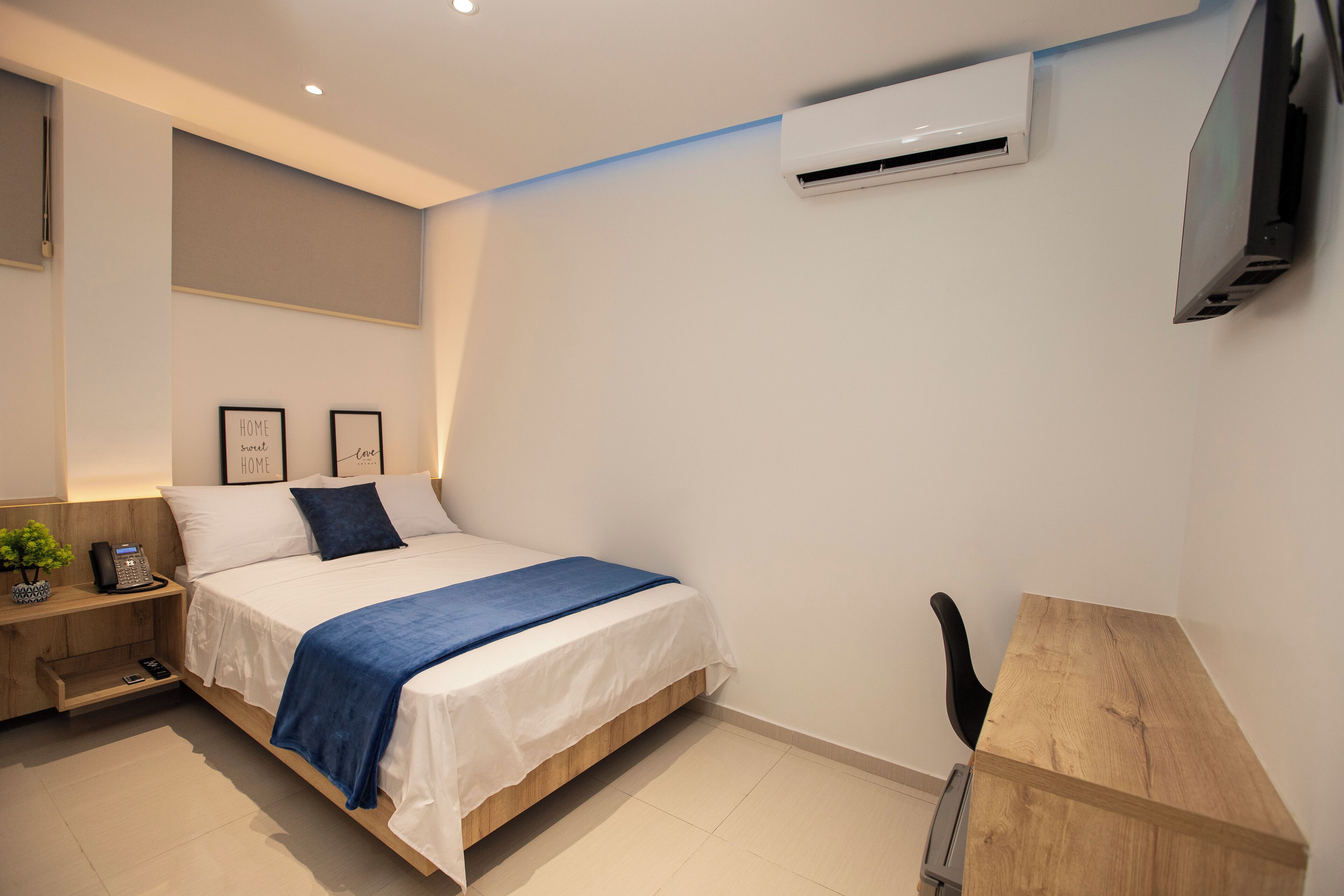 Une chambre à coucher moderne avec un lit, une table de chevet et un bureau.