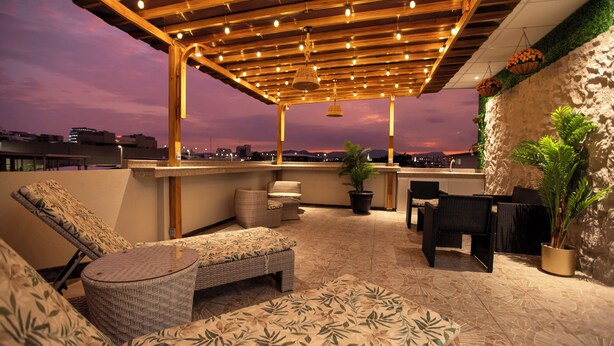 A rooftop terrace with outdoor seating, a bar area, and potted plants. - Harmonie (Guayaquil)