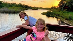 Two people on a wooden bridge over a calm river with a sunset in the background. - Perfect Family Fun  | Pool, King Bed+BBQ+Sleeps 6 (Rockport)