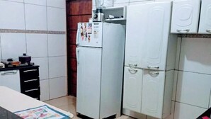 Eine kleine Küche mit Kühlschrank, Mikrowelle und Spüle.