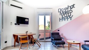 A modern living room with a TV, a dining table, and a comfortable seating area. - Massarenti 14 a Porta San Vitale by Wonderful Italy (Bologna)