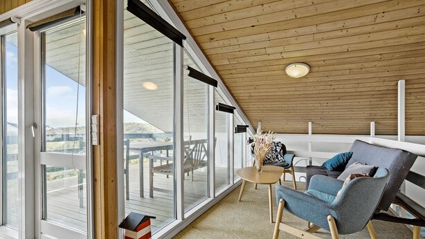 A modern room with a large sliding glass door leading to an outdoor deck, a round table, and two chairs. - Awesome home in Thisted with sauna (Thisted)