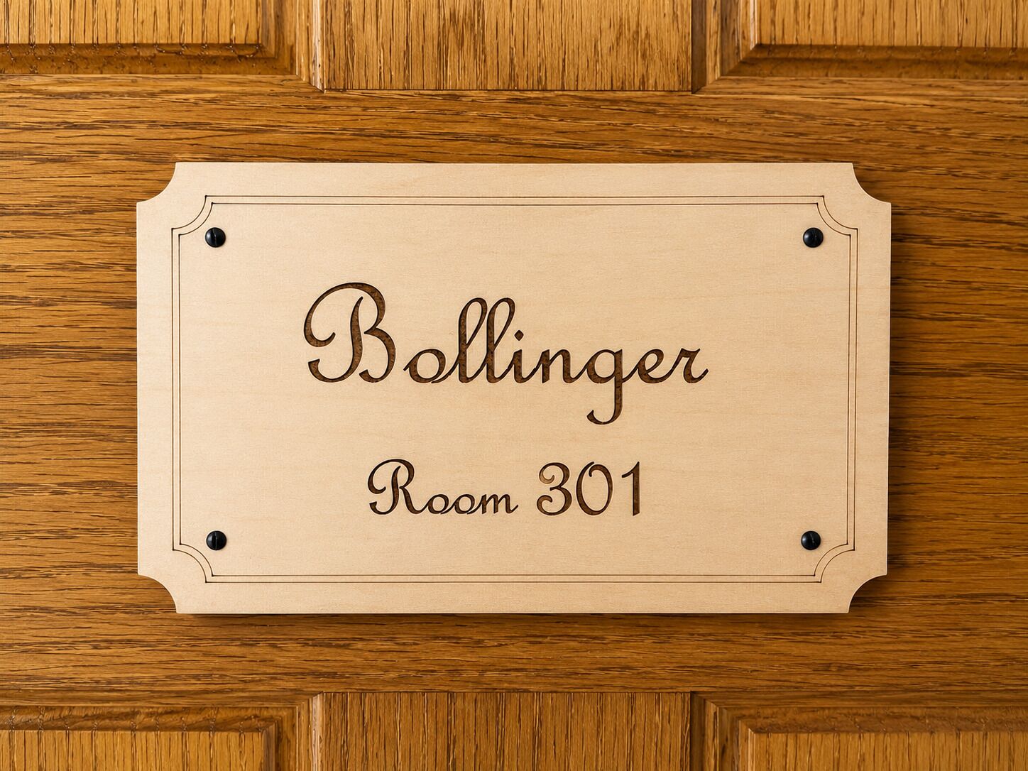 Une plaque en bois portant l’inscription « Salle Ballinger 301 » est fixée à une porte en bois.