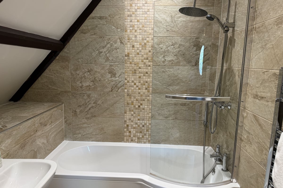 Une salle de bain avec une baignoire, une douche et un lavabo.