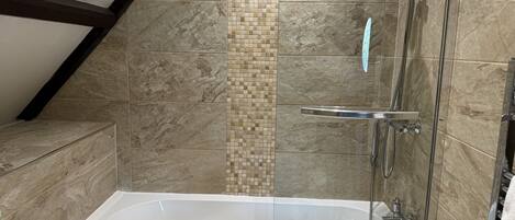 A bathroom with a bathtub, a shower, and a sink.