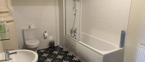 A bathroom with a toilet, sink, shower, and bathtub.