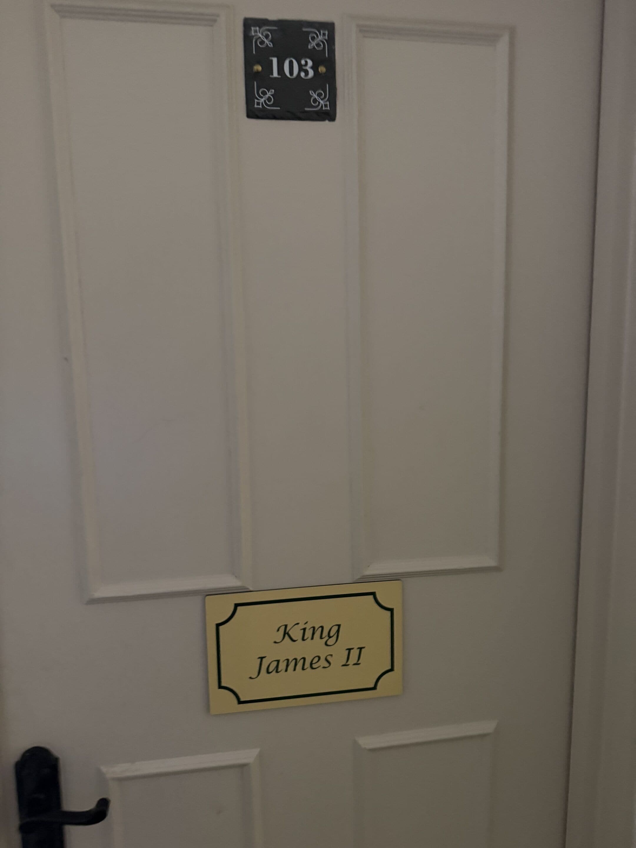 A door with a sign above it reading '103' and a lower sign that says 'King James II'.