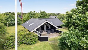 A modern house with a sloped roof, a large deck, and a covered outdoor seating area. - Awesome home in Skjern with WiFi (Skjern)