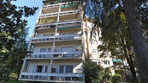 A multi-story residential building with balconies, surrounded by trees and greenery. - Gambara Apartment Travel Inside (Milano)