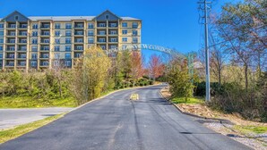 A multi-story hotel with a large entrance archway, a paved driveway, and surrounding greenery. - Fantastic and Convenient Smoky Mountain View Condo! 2104 (Pigeon Forge)