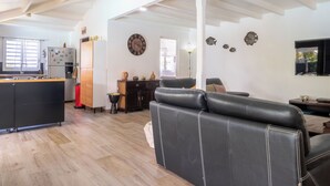 A spacious living area with a kitchen, a dining table, and a sofa. - Tropical escape in an authentic Creole villa with private saltwater pool. (Anse-Bertrand)