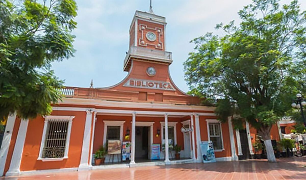 A red brick building with a clock tower and the word 'BIBLIOTECA' on the front.