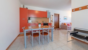 A compact living space with a kitchen, dining area, and seating area. - La Mimosa B03 Apartment by Wonderful Italy (Peschiera del Garda)