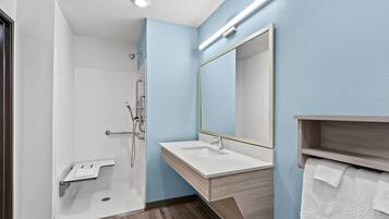 A modern bathroom with a shower, sink, and mirror.