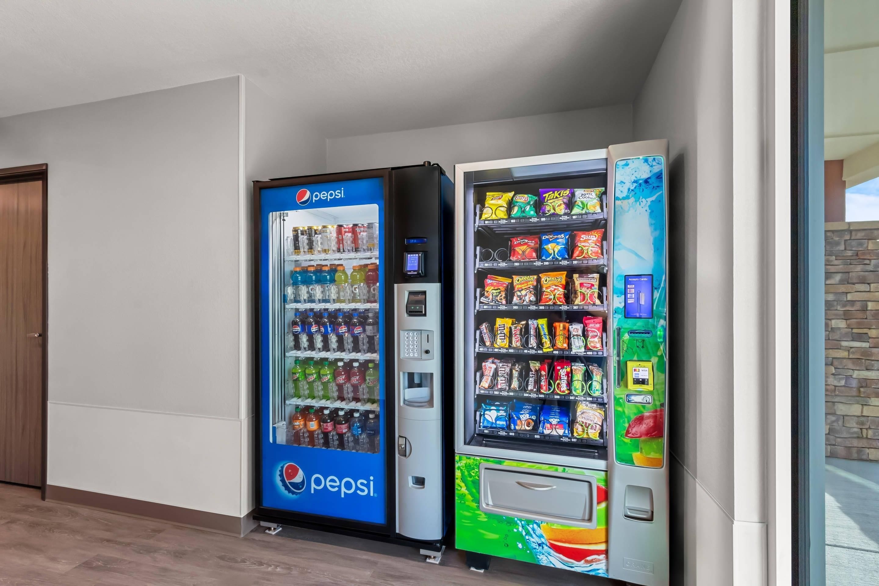 A vending machine area with a Pepsi machine and a colorful snack vending machine.