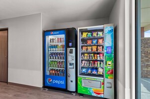 Zona de máquinas expendedoras con una máquina de Pepsi y otra de aperitivos coloridos.