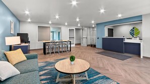 Una sala moderna con sofá, mesa de centro y comedor con sillas y mesa.
