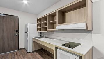 A modern kitchen with a built-in refrigerator, a sink, and a microwave.