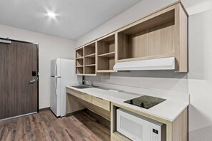 Una cuina moderna amb nevera integrada, un rentapeus i un microones.